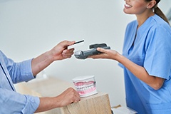 A patient using a credit card to pay the cost of cosmetic dentistry