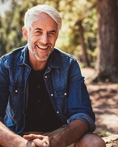 man with dental implants in Allentown sitting in a park