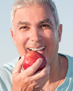 Man with dentures in Allentown biting an apple