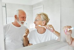 couple in front of the mirror brushing (for oral hygiene section)