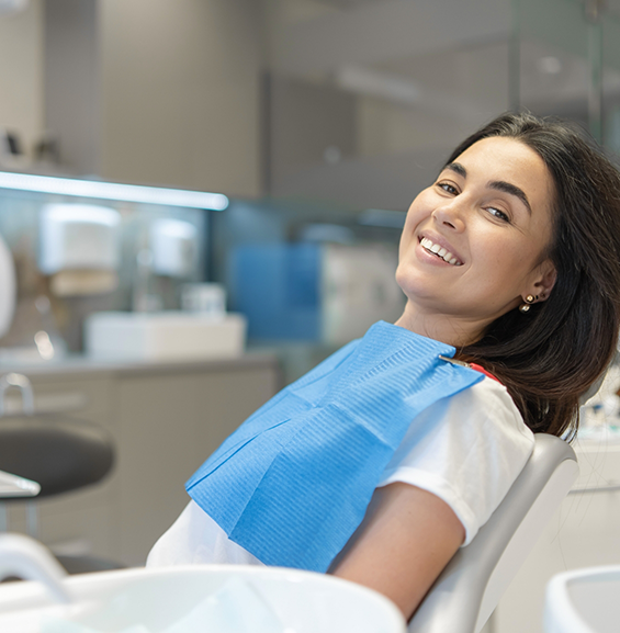 Smiling woman leaning back in the dental chair