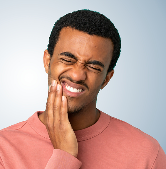 Man holding his cheek in pain