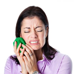 Woman in need of root canal holding ice bag to cheek