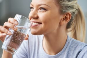 woman drinking water smiling