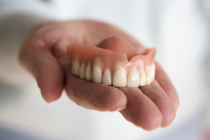 Person holding dentures in Allentown