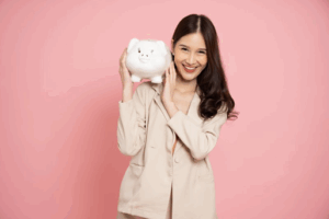 Woman smiling while holding a piggy bank