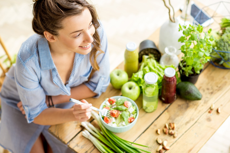 Patient with good oral health smiling and eating green food